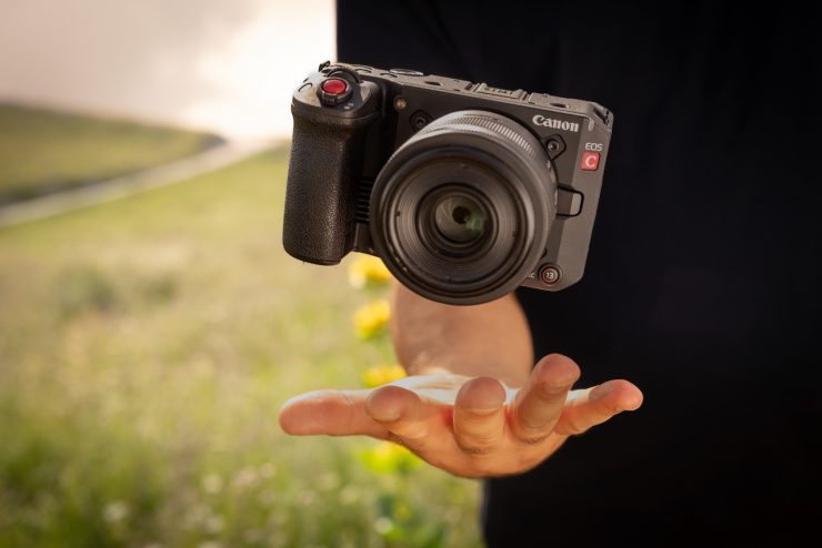 D227 Lifestyle, small and lightweight with 35mm RF f1 8 IS macro, camera mid air above a male hand